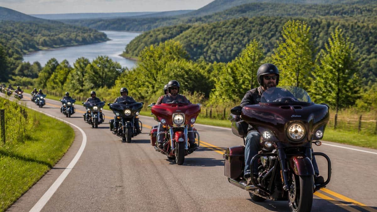 Motorcyclists enjoy camaraderie while participating in scenic group rides along a sunlit river and rolling hills.